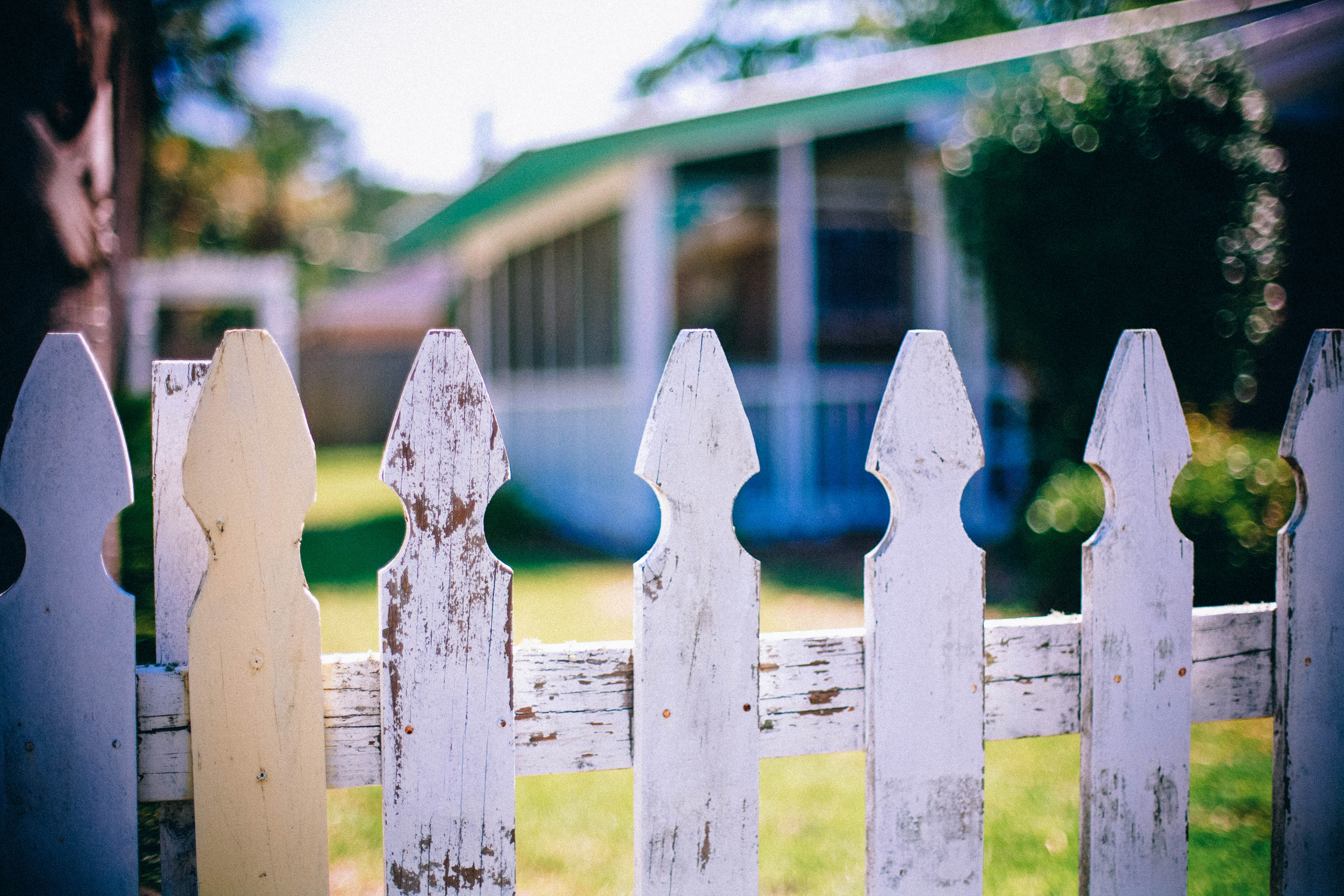 Fencing around house fallen into neglect and disrepair, as it might when a family goes through divorce